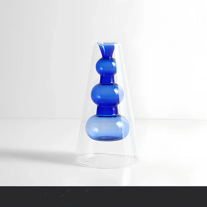 Transparent glass vase with colourful inner layer displaying dried flowers, 15cm tall on wooden table