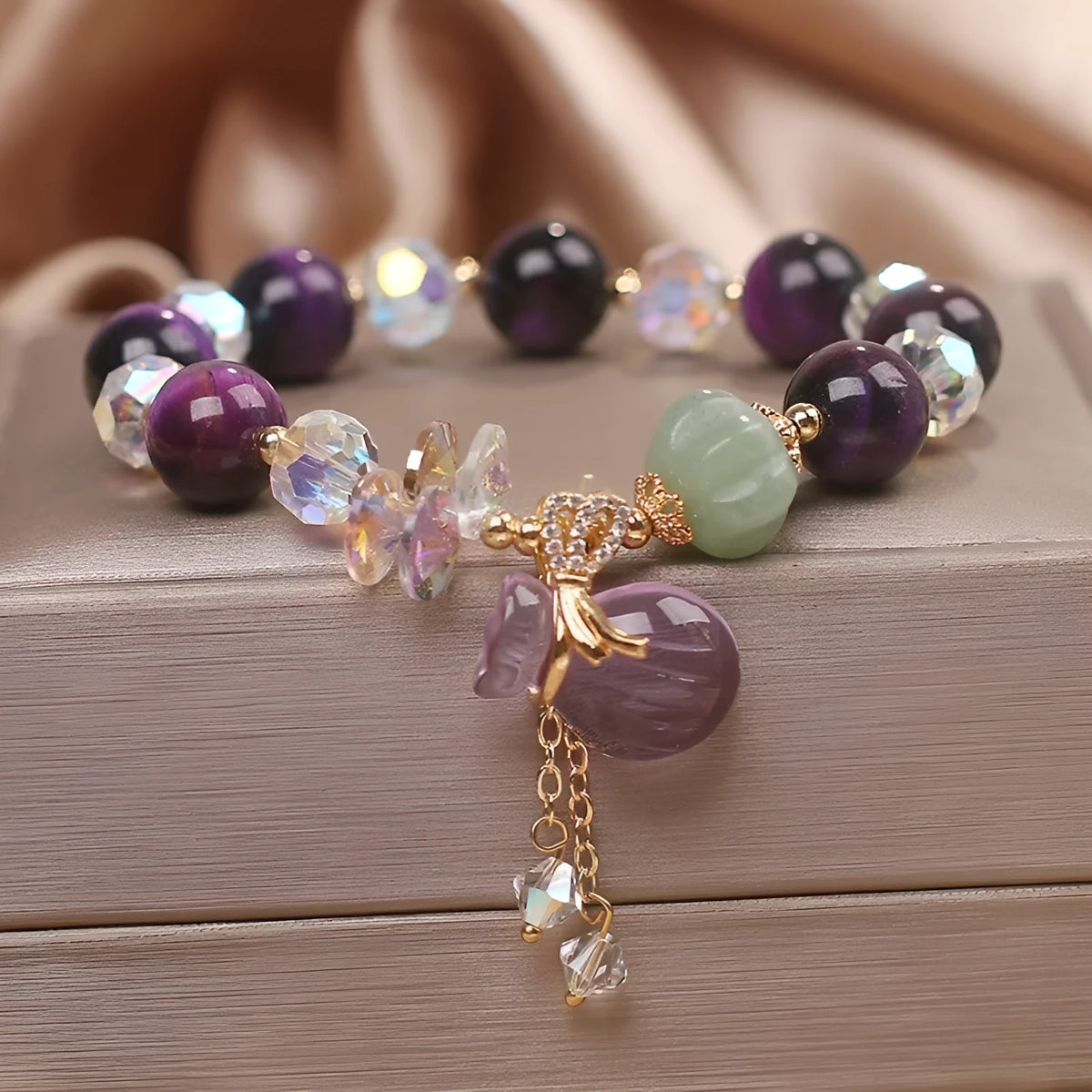 Women's forest style crystal bracelet with purple tigereye money bag pendant and rhinestone details