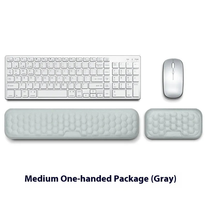 Black and grey memory foam mouse wrist rests with cloth and leather-style covers on a desk.