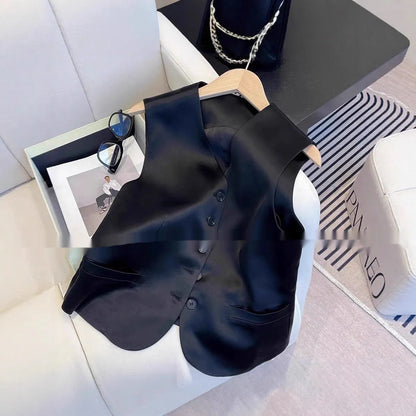 Black satin sleeveless vest for women on a hanger, showing loose fit and splicing detail.