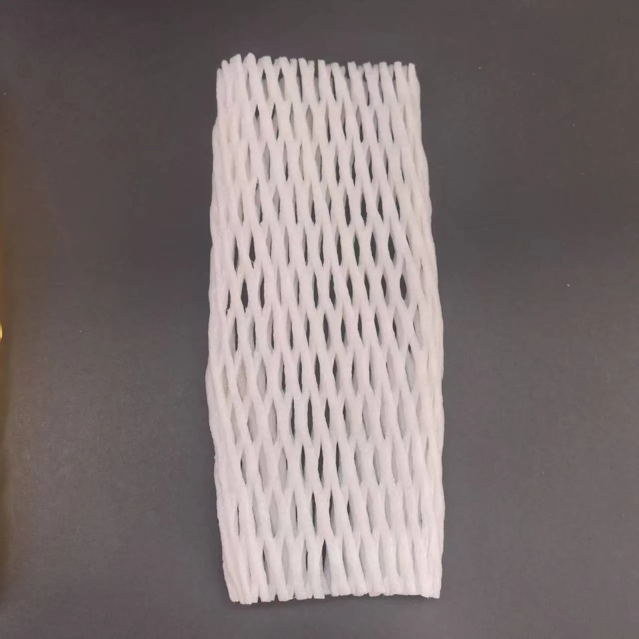 A white foam protective net sleeve stretched open, showing its simple tubular construction.