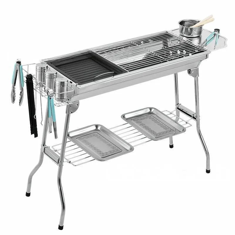 Stainless steel portable barbecue oven with flip mechanism showing checked iron grills and charcoal stove
