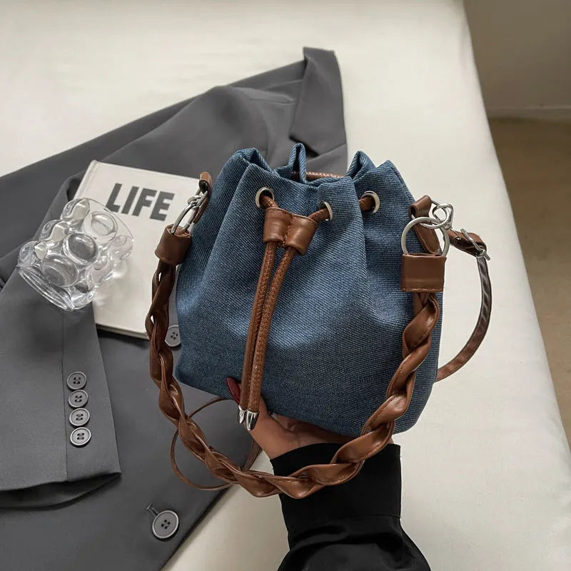 Blue synthetic leather cross body bucket bag with adjustable strap and optional hanging ornaments