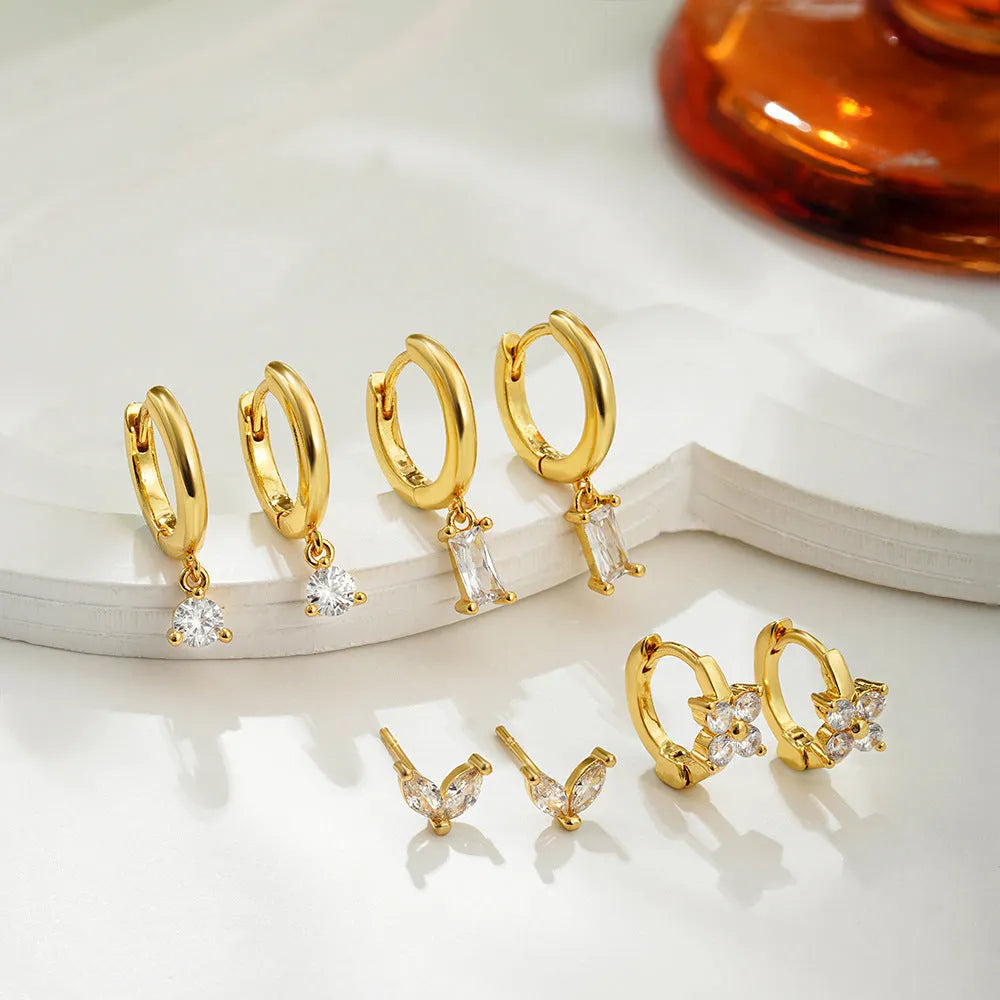 A set of geometric and star-shaped copper earrings with zircon accents in gold or silver plating.