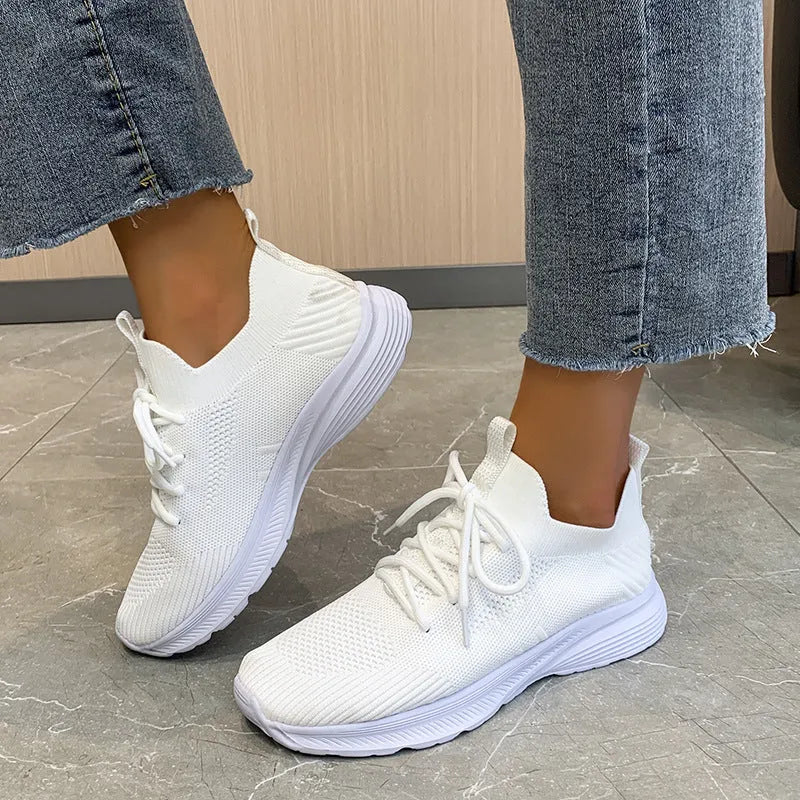 Women's low-top mesh Flyknit tennis shoes in creamy white, with a rubber sole and round toe.