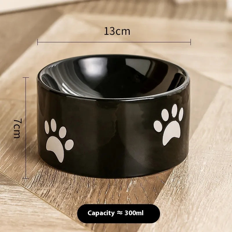 Ceramic cat bowl with high foot and cat's paw base in an oblique mouth design.