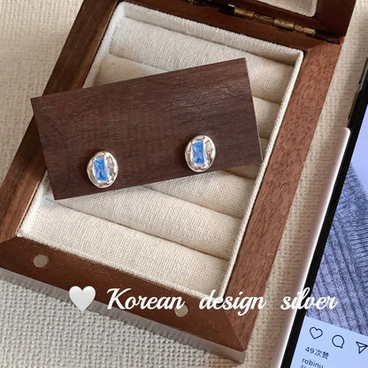 Women's S925 sterling silver earrings with oval blue diamond heart-wrapped design