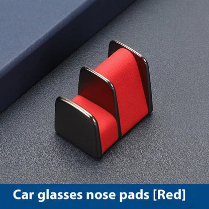 Green zinc alloy and leather glasses clip holder attached to a car dashboard, holding sunglasses.