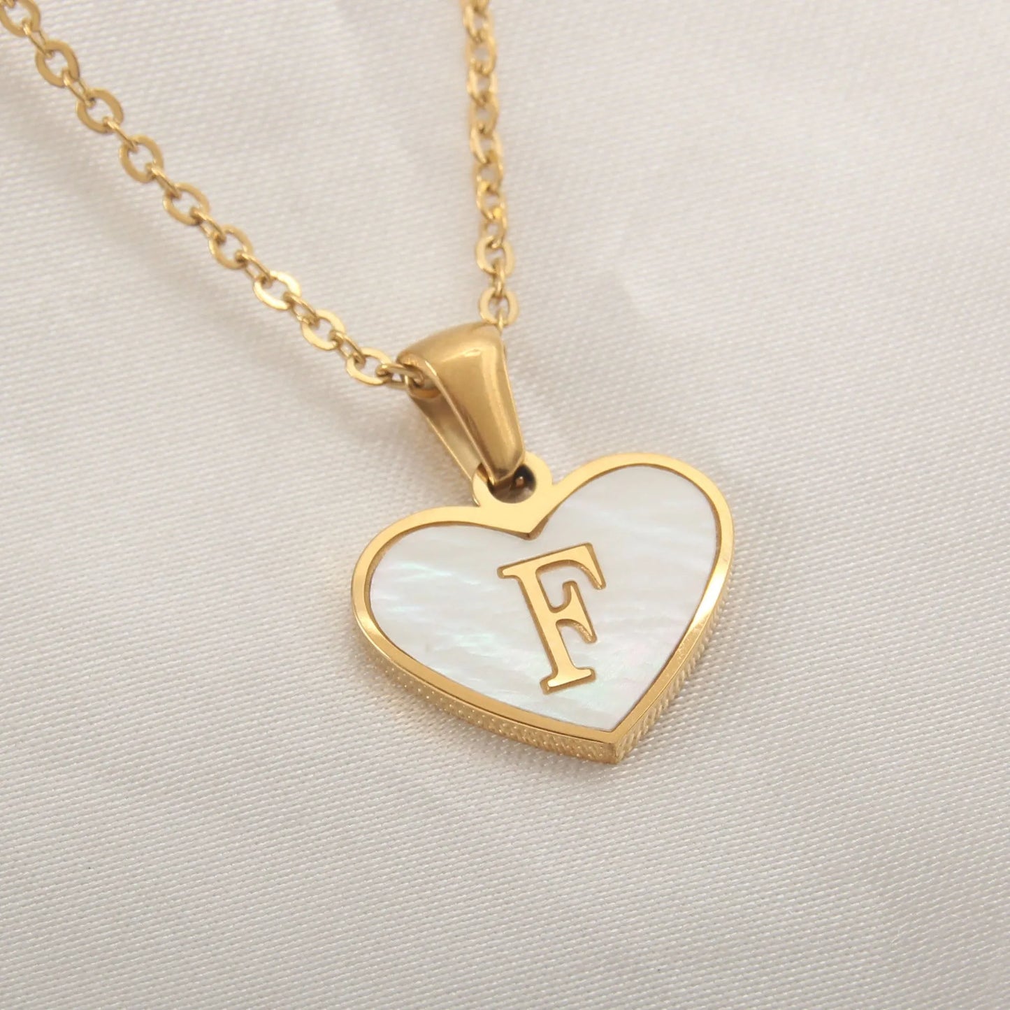Gold-plated clavicle necklace with a white shell heart pendant, personalised with a letter from A to Z.