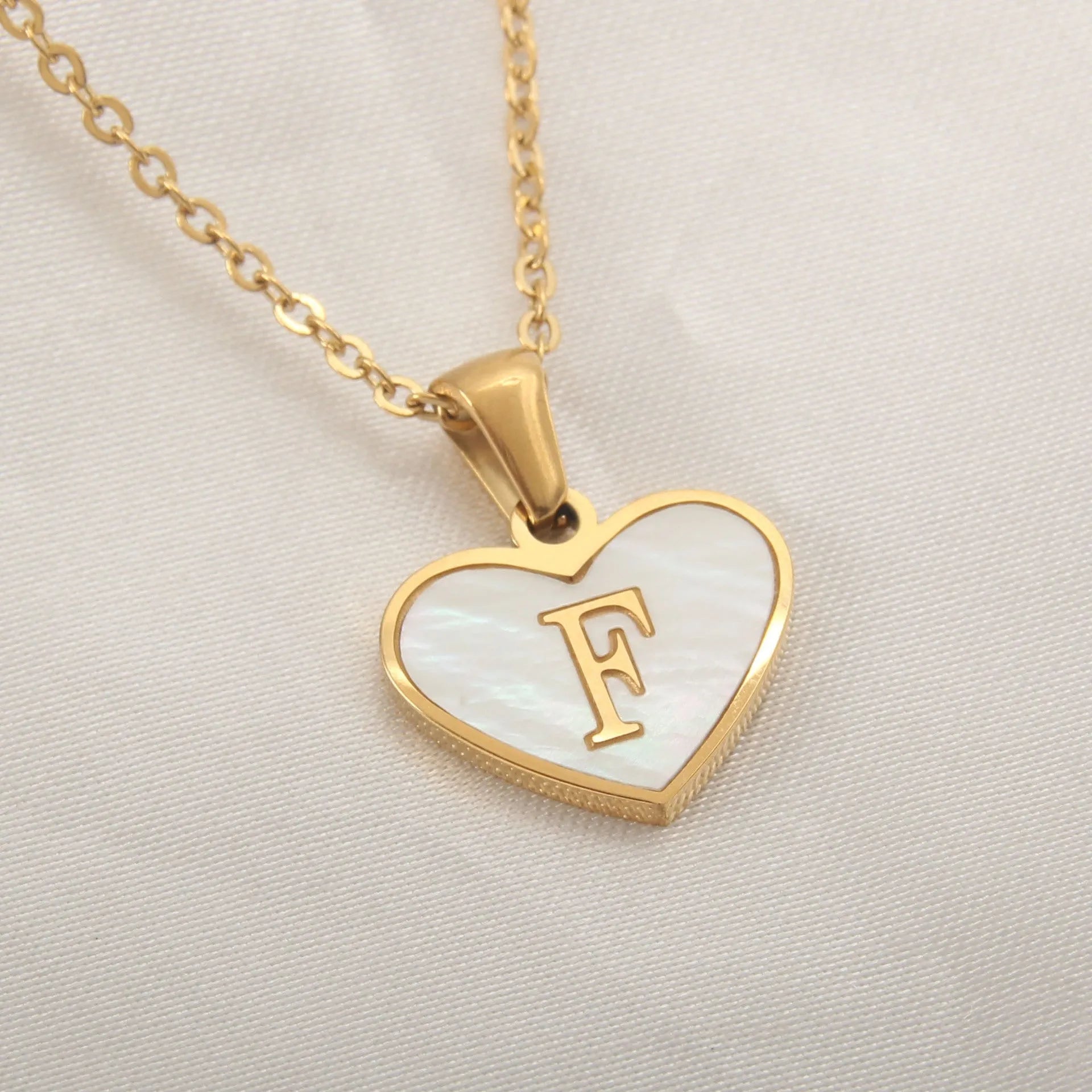 Gold-plated clavicle necklace with a white shell heart pendant, personalised with a letter from A to Z.