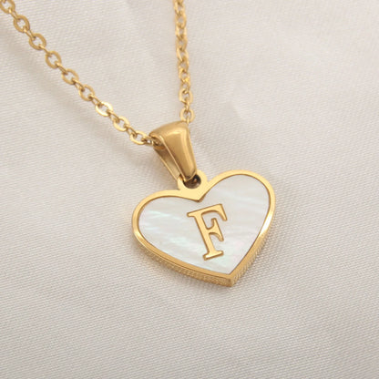 Gold-plated clavicle necklace with a white shell heart pendant, personalised with a letter from A to Z.