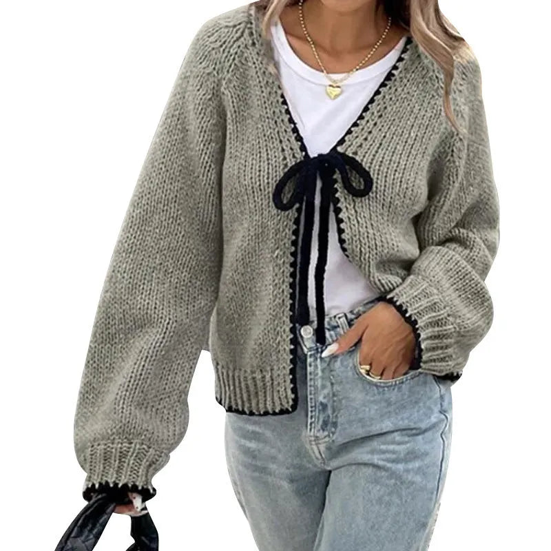 Loose grey lace-up front cardigan sweater with crocheted flower detail on a model.