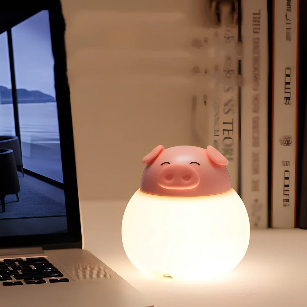Pink silicone pig-shaped bedside lamp with adjustable lighting on wooden table