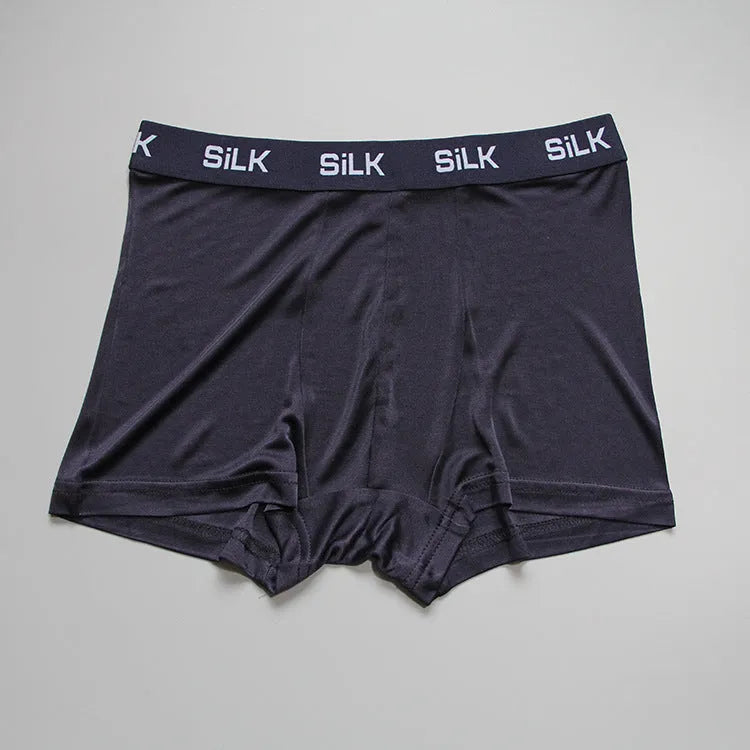 Men's loose-fitting silk shorts in navy blue on a neutral background.