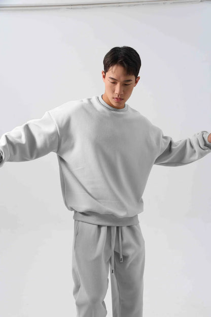 Man wearing a two-piece army green polar fleece suit with crew neck top and padded trousers.