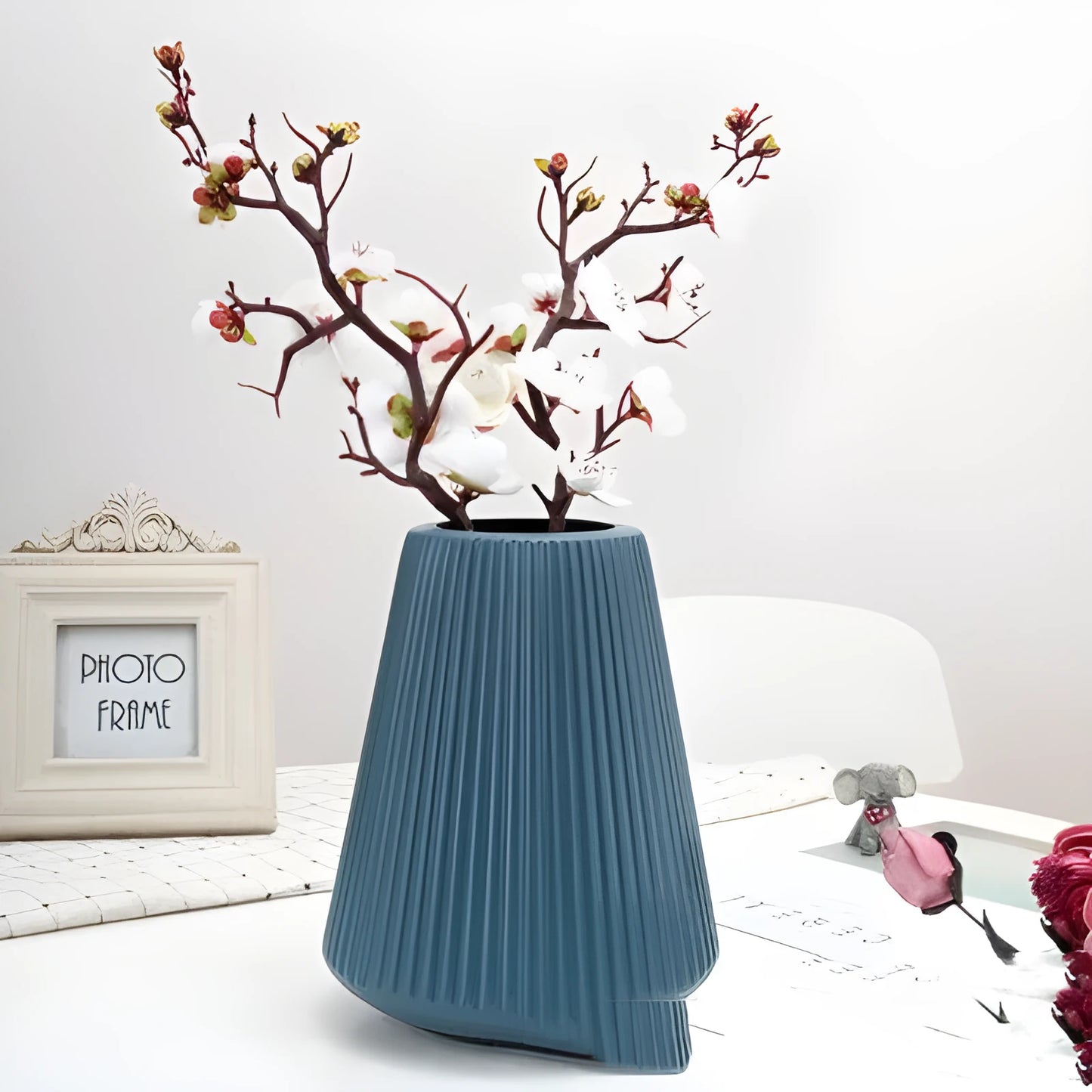 Melamine plastic decorative vase in blue colour measuring 16cm by 20cm on wooden desk