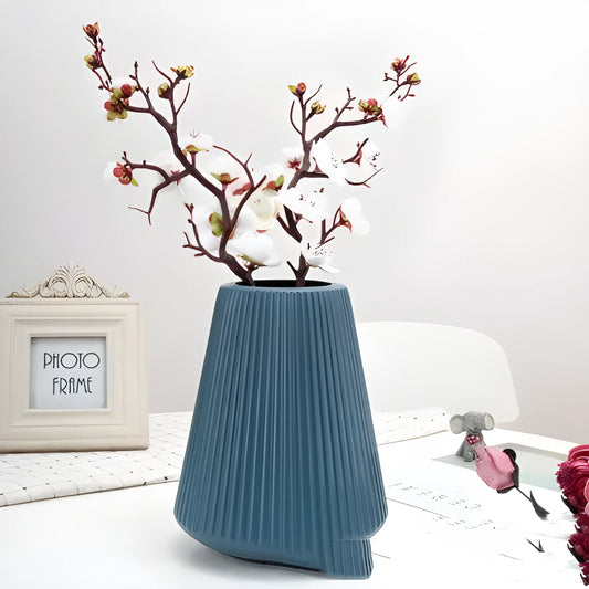 Melamine plastic decorative vase in blue colour measuring 16cm by 20cm on wooden desk