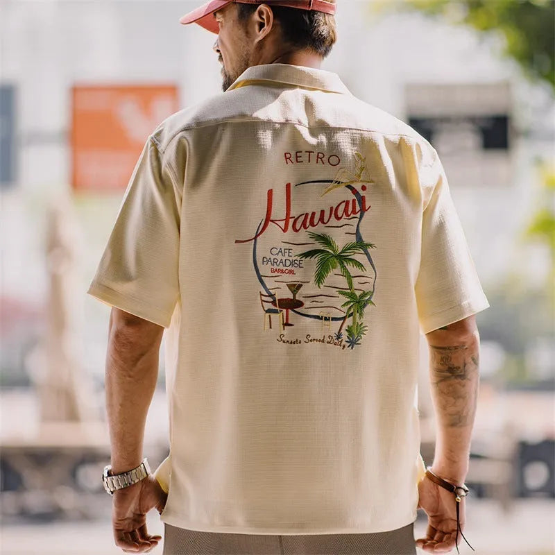 Light apricot men's shirt with a bamboo plant pattern and a Cuban collar laid flat.