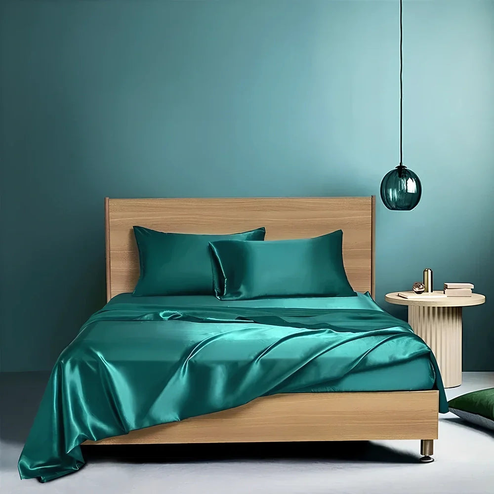 Navy blue floral pattern silk bedding set with quilt cover, fitted sheet, and two pillowcases on bed