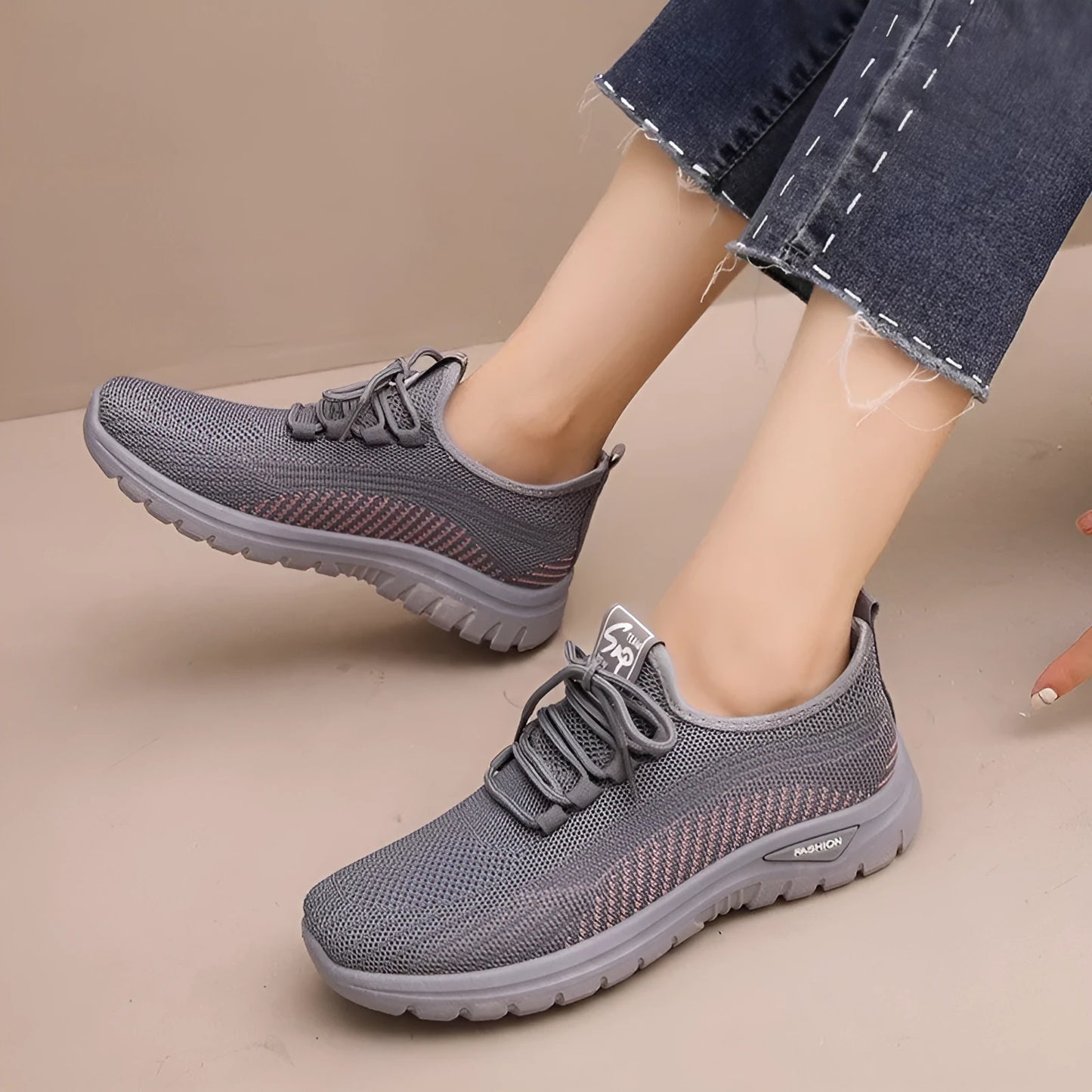 Women's low-top sneakers in black with a cross strap detail on the artificial PU and mesh upper.