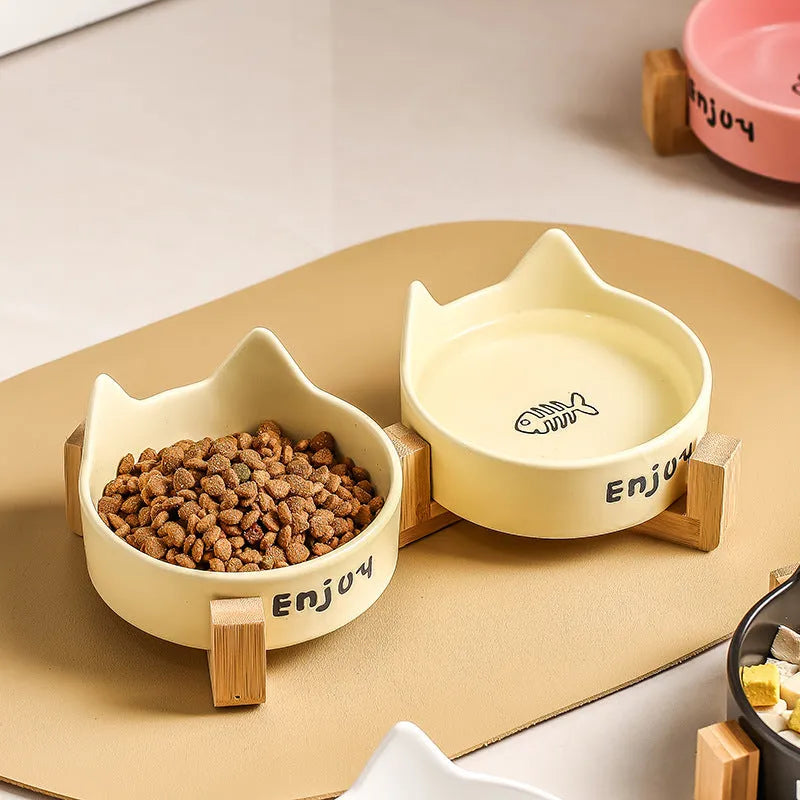 Porcelain cat bowl with anti-tumble wooden frame in pink with a cat paw design