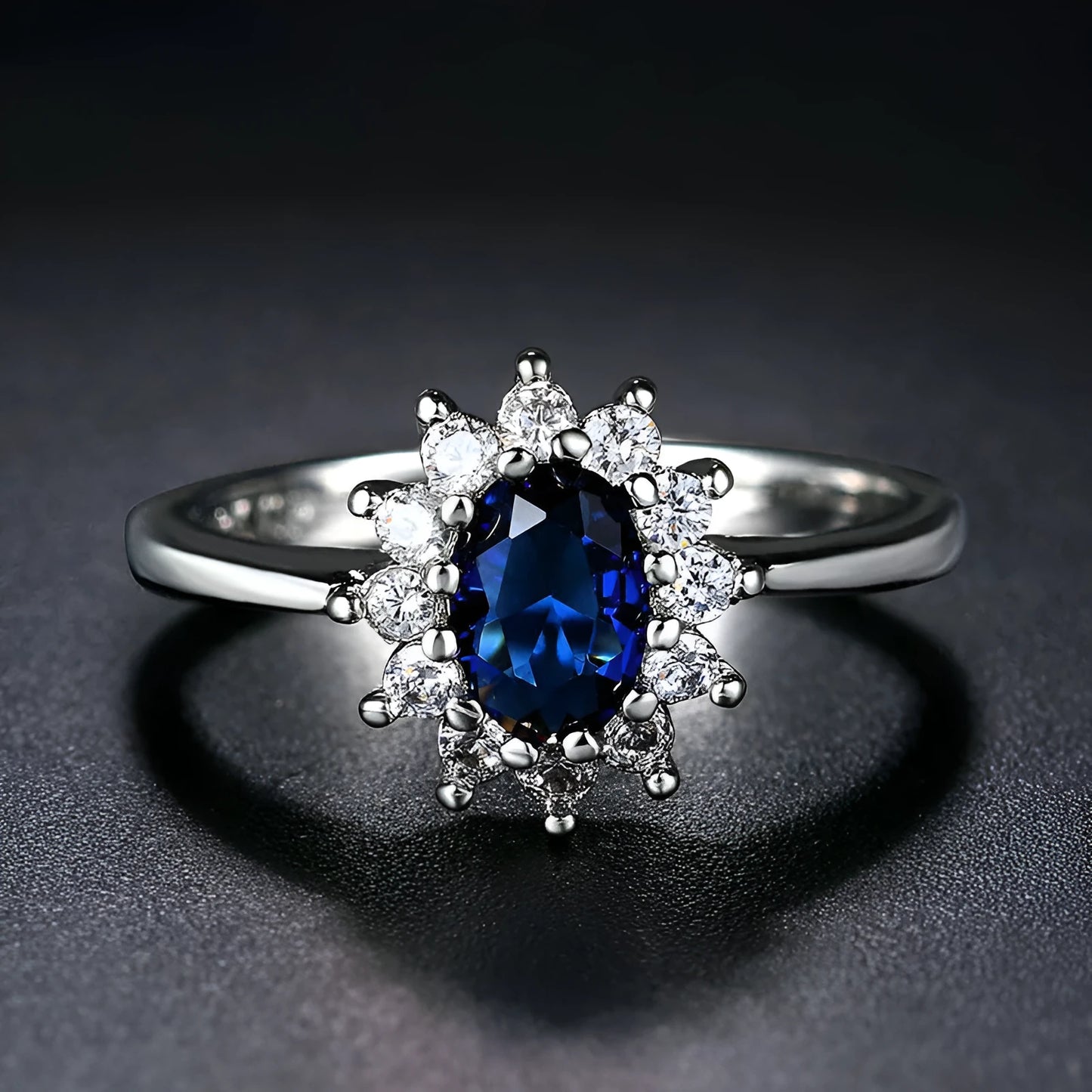 A women's copper ring with a flower design and a central zirconium stone, shown in green, blue, and red colour options.