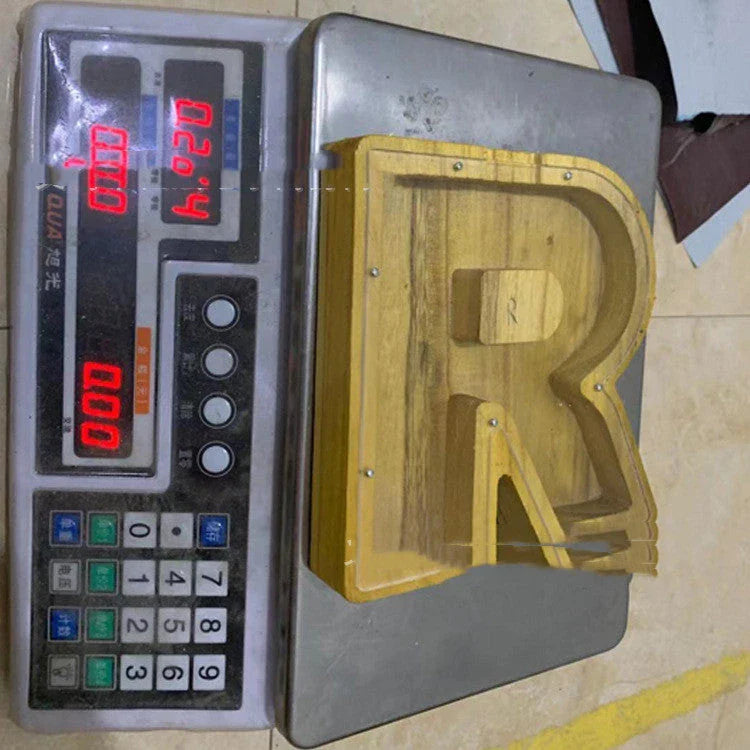 Wooden letter-shaped coin bank with clear glass panel to watch savings grow, a decorative and functional home accent.