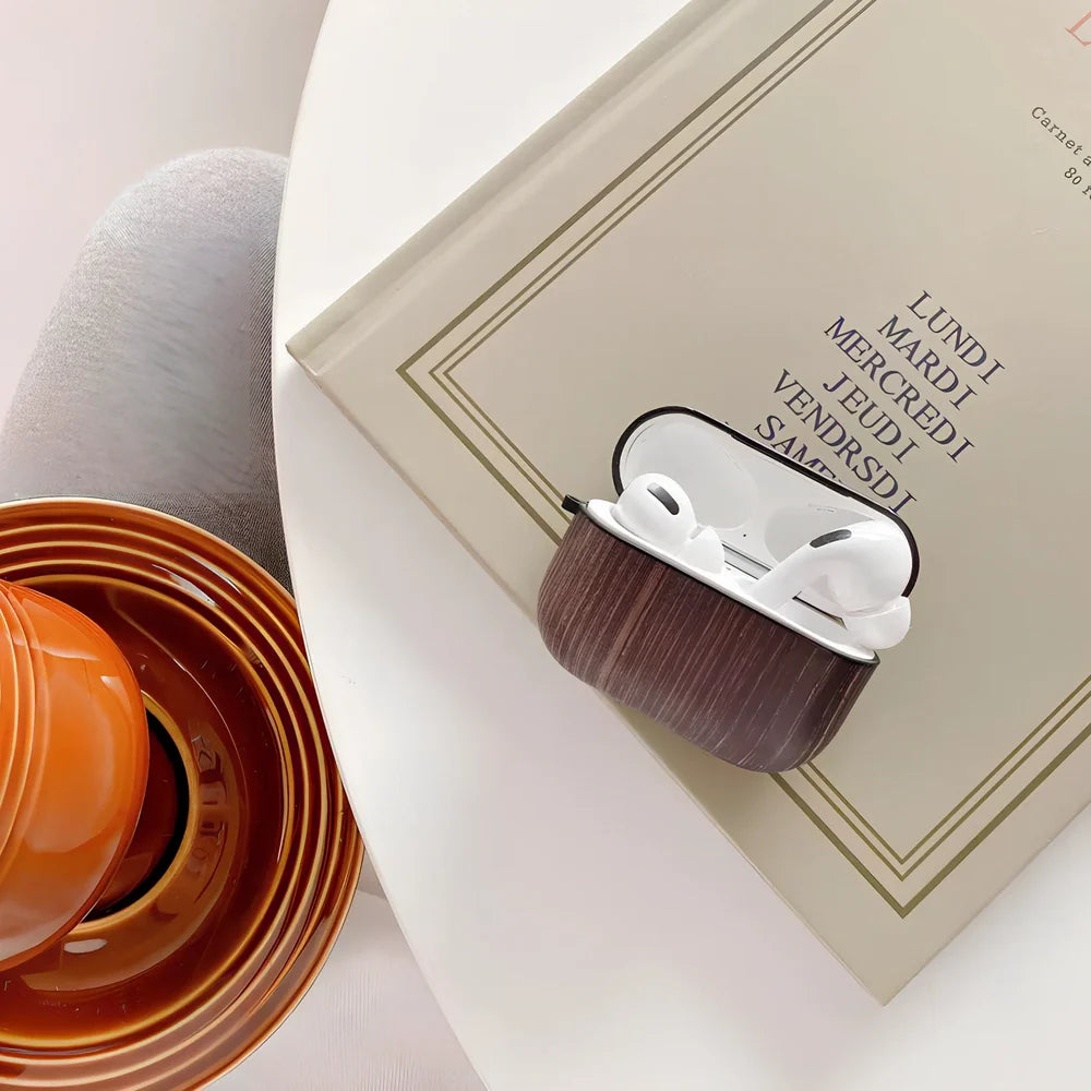 Wood grain AirPods case with IMD clamshell design showing six colour options including dark brown and red brown patterns