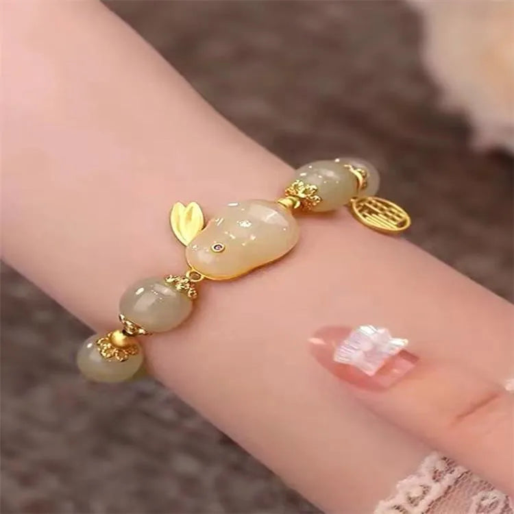 Green jade hare charm fu character bracelet with lily detail on black adjustable cord.
