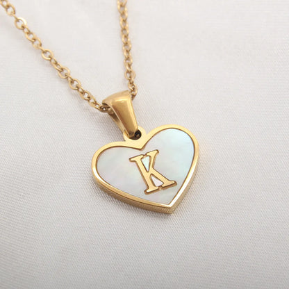 Gold-plated clavicle necklace with a white shell heart pendant, personalised with a letter from A to Z.
