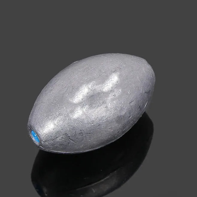 Rugby-shaped lead fishing sinker with scaled texture and plastic core protection for sea fishing