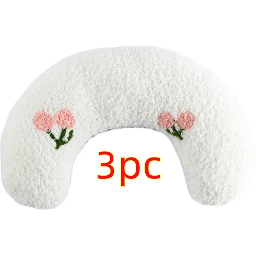 White U-shaped pet pillow measuring 27cm with raised rim supporting small cat's neck and back