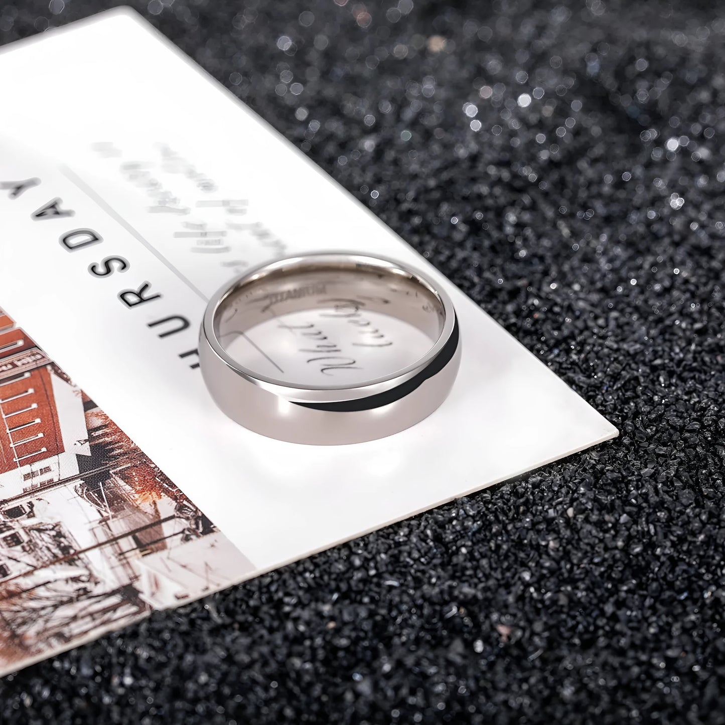 Silver titanium steel unisex ring with grinding texture on finger, showing different band width options.
