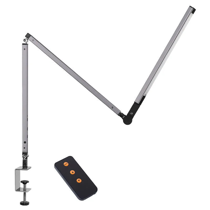 Clip-on adjustable arm LED desk lamp in black mounted on a desk edge with remote control.