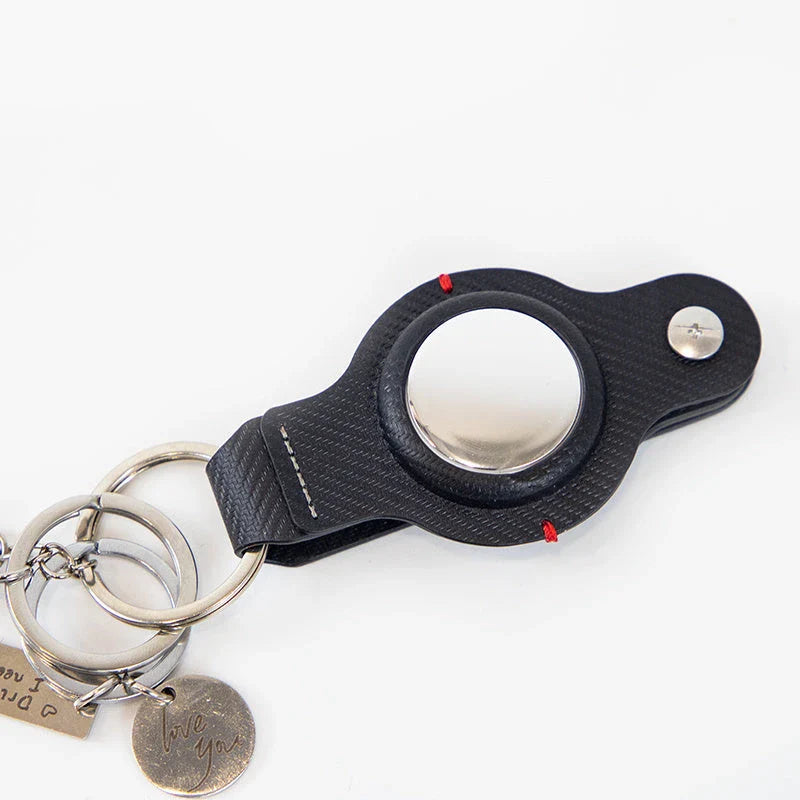 Stylish and secure AirTag holder keychain in black and grey PU leather, with a sturdy key ring for attaching to valuables