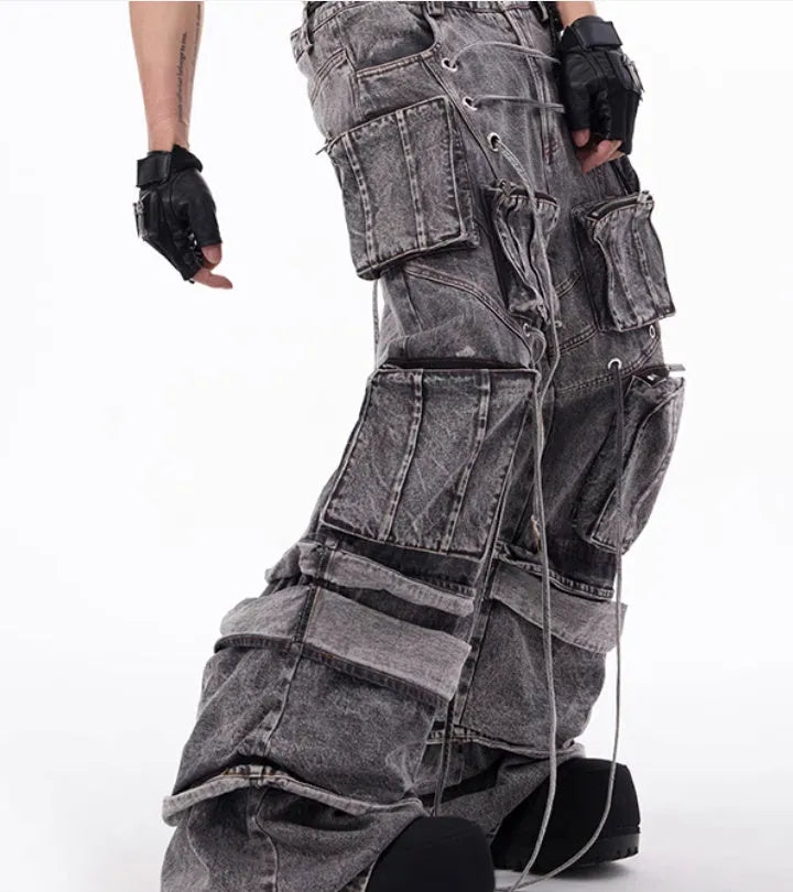 Grey distressed denim overalls with rope stitching on a man, showcasing the mop pant style.