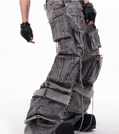 Grey distressed denim overalls with rope stitching on a man, showcasing the mop pant style.