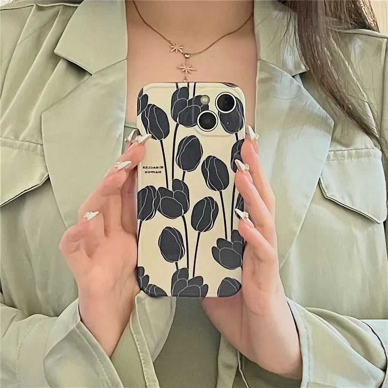 Cold Wind black silicone iPhone case with a white tulip floral pattern on the back.