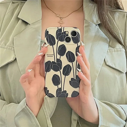 Cold Wind black silicone iPhone case with a white tulip floral pattern on the back.