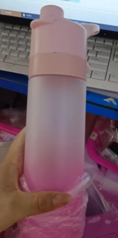Large plastic spray water bottle with handle strap and leakproof lid in green colour.
