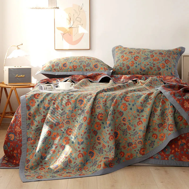 Three-piece cotton gauze bed set with floral print, showing blanket and pillowcases on a bed.