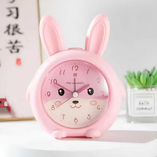 Cartoon-style children's alarm clock in pink or blue, showing buttons for night light and alarm functions.
