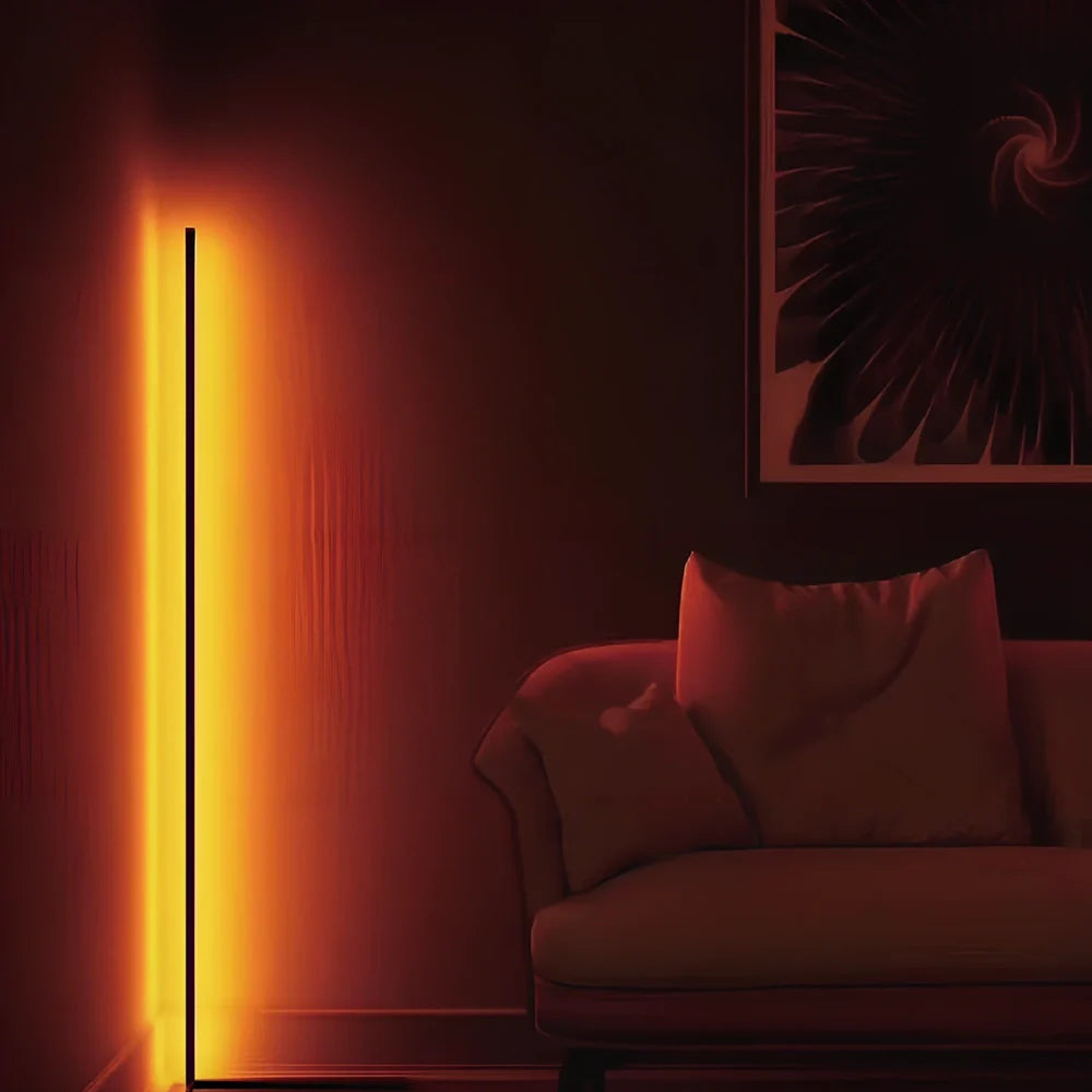 Black smart RGB floor lamp with remote control showing colour-changing illumination in bedroom setting