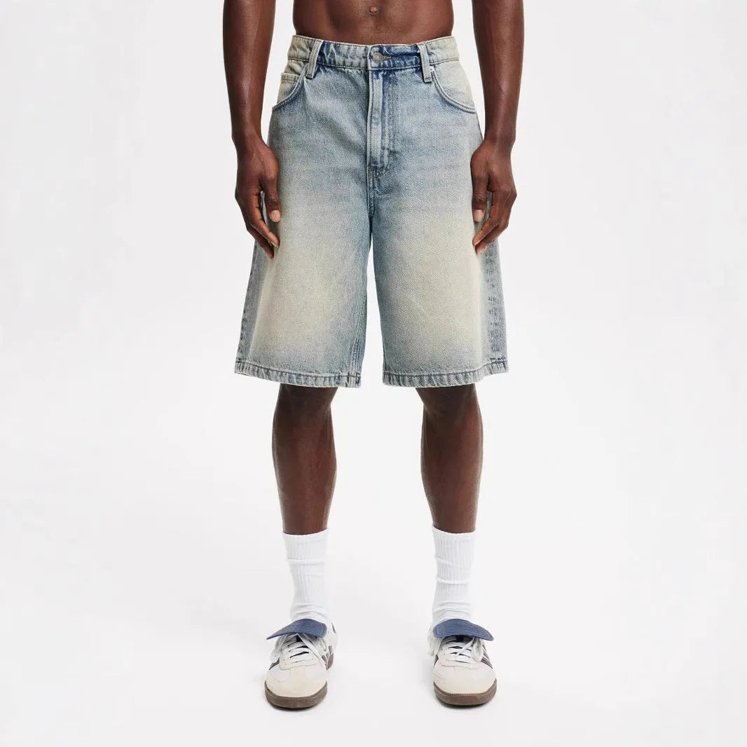 Men's light blue loose-fit straight-leg cotton jeans on a neutral background.