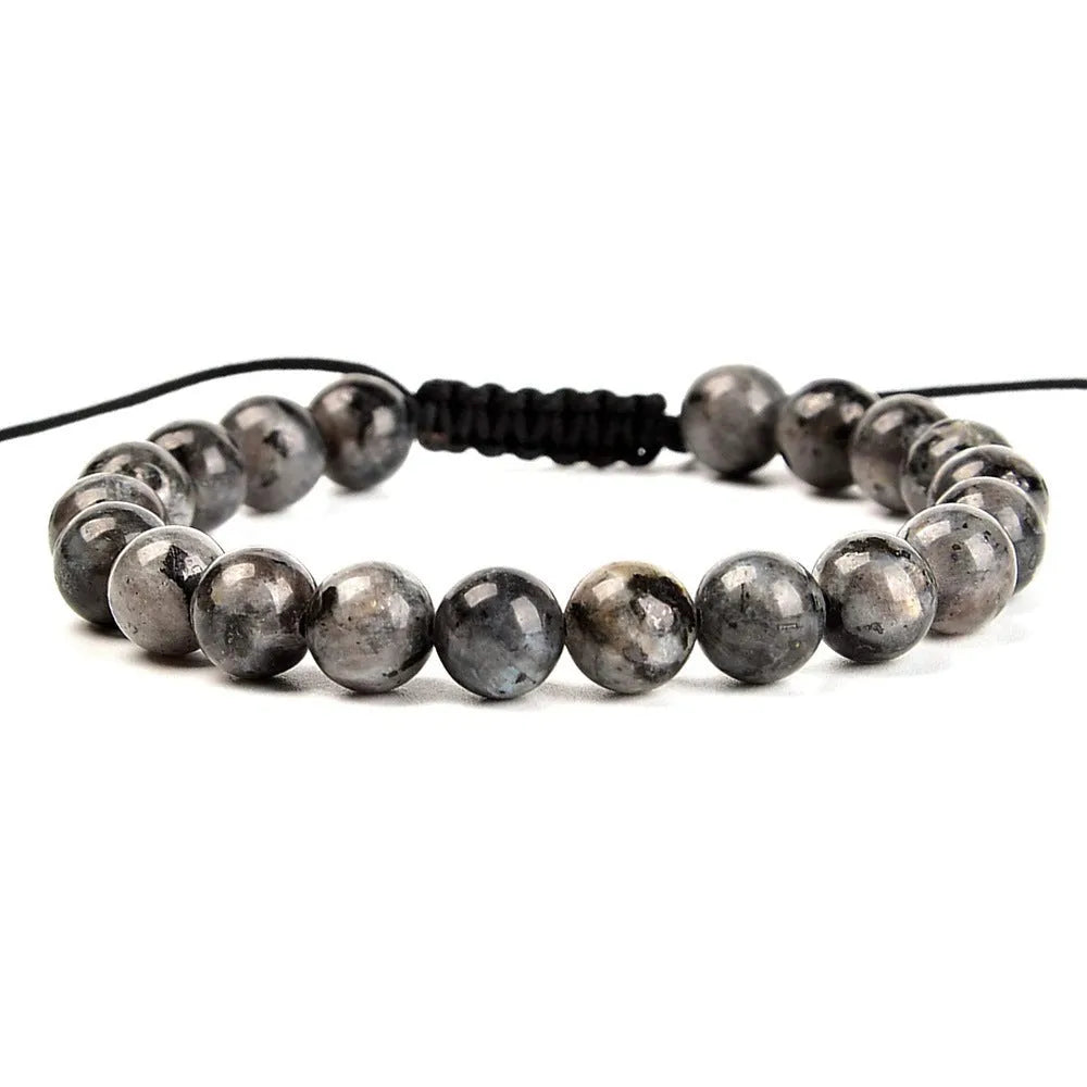 Close-up of a women's flat knot braided healing bracelet hand-woven with colourful gemstones.