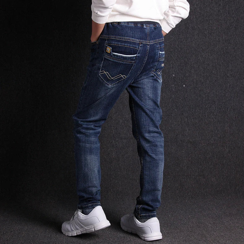 Boys' black micro-stretch cotton jeans showing 4-way flexibility and middle waist design