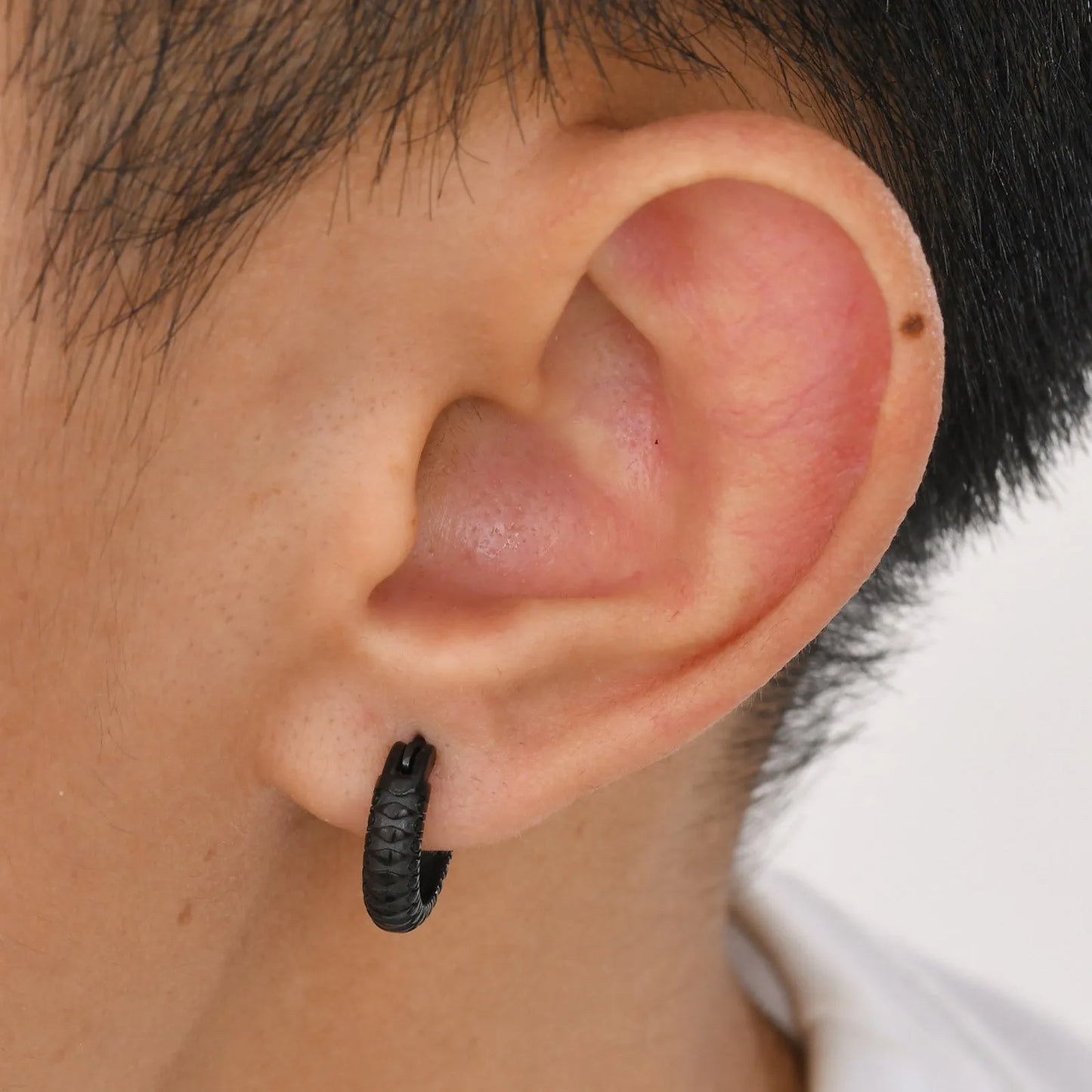 Pair of stainless steel earrings with snake pattern texture in black finish, 1.5cm diameter