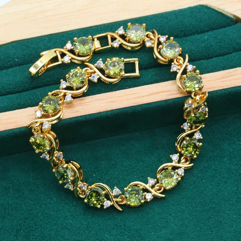 Olive green zircon jewellery suit set showing necklace with snake bone chain, matching earrings, and ring on a display.