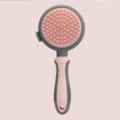 Pink double-sided cat brush with release button showing smooth brush side and flea comb side for grooming indoor cats