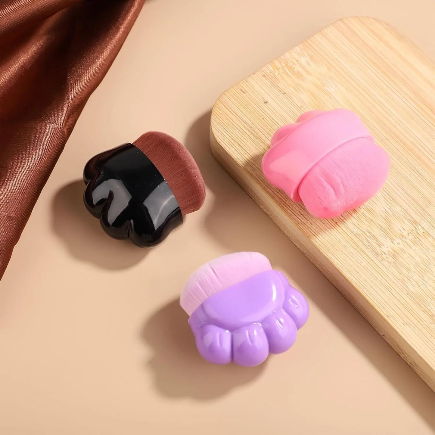 Three small paw-print shaped pet balm brushes with soft heads in plastic storage boxes